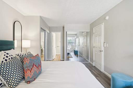A bedroom with a large bed and a blue stool.