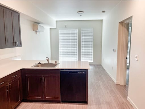 A kitchen with wooden cabinets and a black dishwasher.
