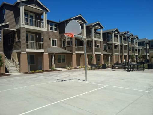 a basketball hoop in front of an apartment complex