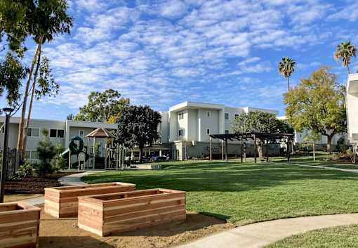 A white building with a green lawn in front of it.