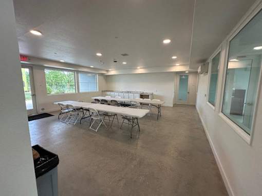 A room with tables and chairs is empty and ready for an event.