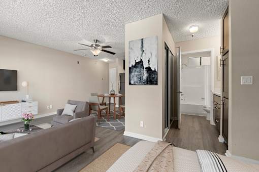 A living room with a grey couch and a painting on the wall in a studio apartment at Harbor Terrace Apartments, California, 90731