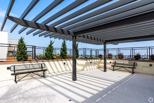 A patio with a bench and a roof.