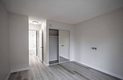 an empty living room with white walls and wood floors at The Arbors Santa Ana, California, 92705
