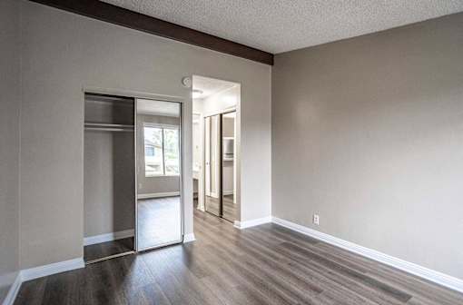 an empty living room with a sliding glass door to a closet at The Arbors Santa Ana, California, 92705