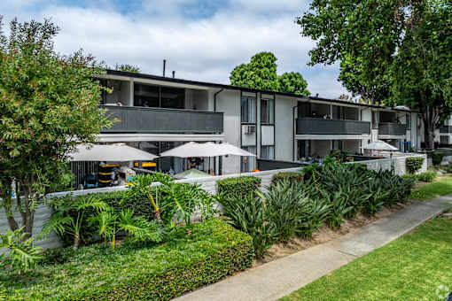 A modern building with a green lawn in front at The Arbors Santa Ana, California, 92705