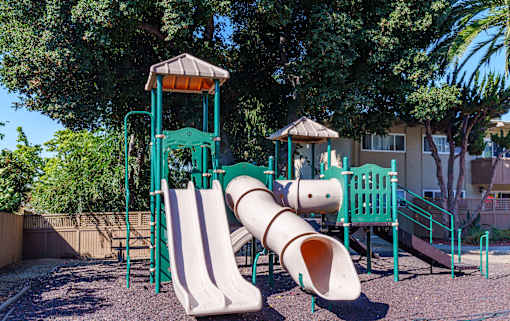 a playground with two slides and a tube