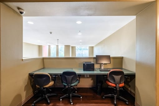 an office with a desk and chairs and a window