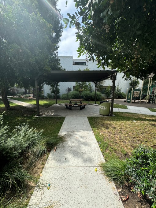 a picnic area in a gazebo with a playground next to it