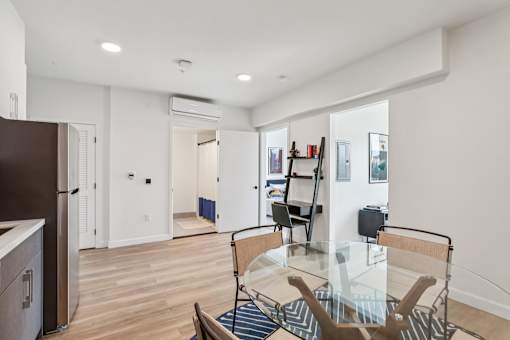 A modern kitchen with a glass dining table and chairs.