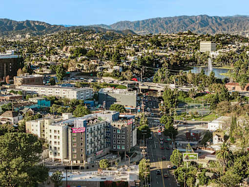 A cityscape with buildings, roads, and mountains in the background.