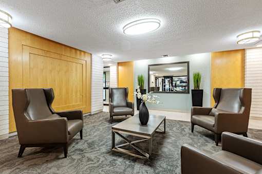 A conference room with brown chairs and a wooden door.