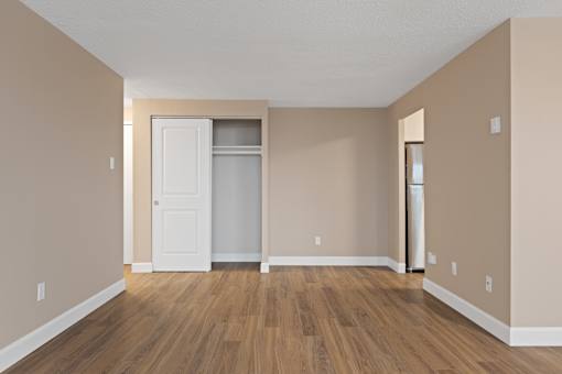 A room with a white door and a white fridge.