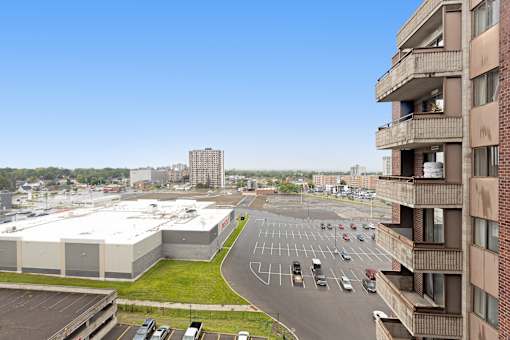A parking lot is in the foreground of a city scene.