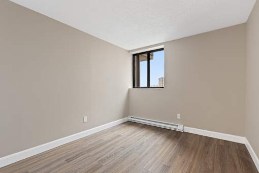 A room with a window and wooden flooring.