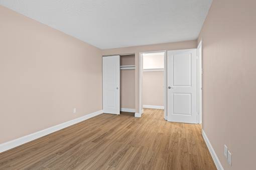 A room with a white door and a white closet with a white door.