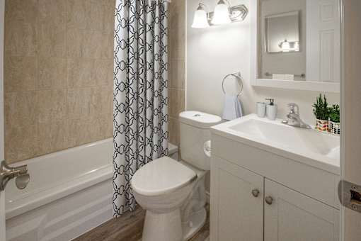 A white toilet sits next to a white sink in a bathroom.