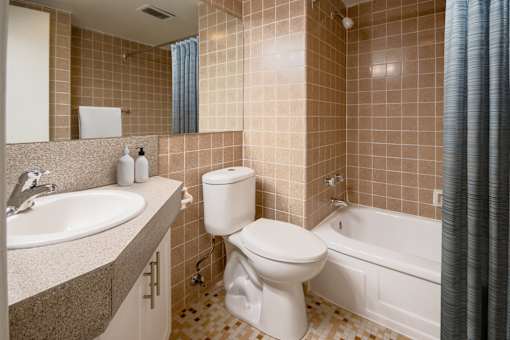 A bathroom with a toilet, sink, and bathtub.