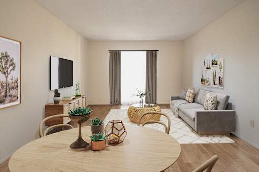 A living room with a wooden table and chairs, a couch, and a TV on the wall.
