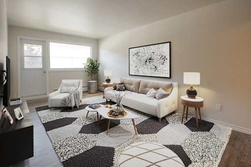 A living room with a white couch, a coffee table, and a large abstract painting on the wall.