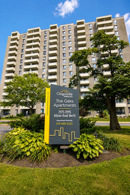 A sign for Osgood Apartments is in front of a building.