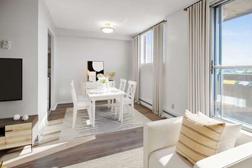 A white dining room with a wooden table and chairs.