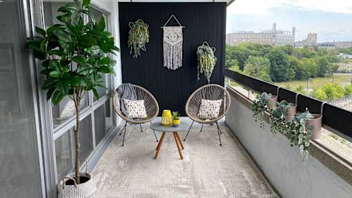 A balcony with two chairs and a table.
