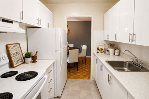 A kitchen with white appliances and cabinets.