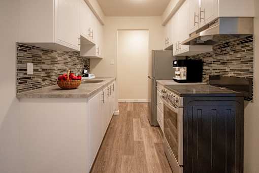 A kitchen with a black oven and a microwave on the counter.