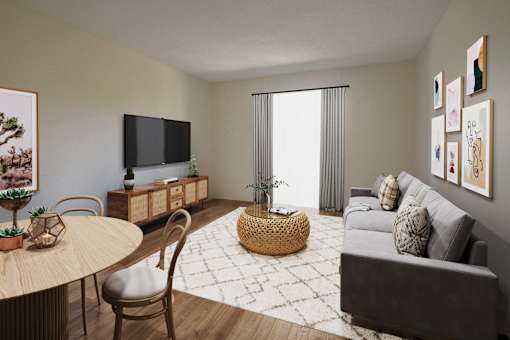 A living room with a grey couch, a round table, and a television.