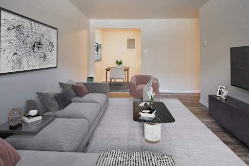 A living room with a grey couch, a coffee table, and a painting on the wall.