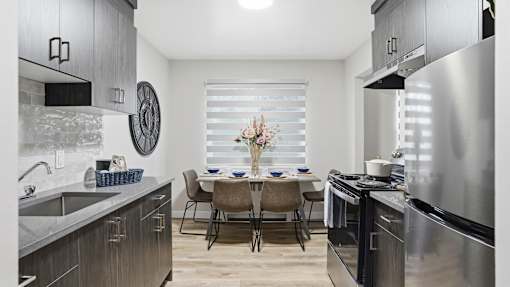 A modern kitchen with a dining table set for four.