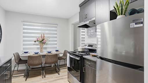 A modern kitchen with a dining table set for four.