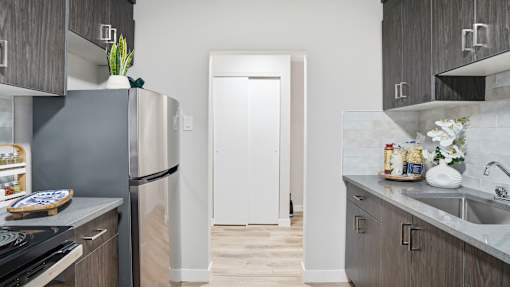 A kitchen with a white refrigerator and wooden cabinets.