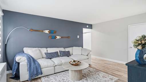 A white couch with a blue throw blanket on it.