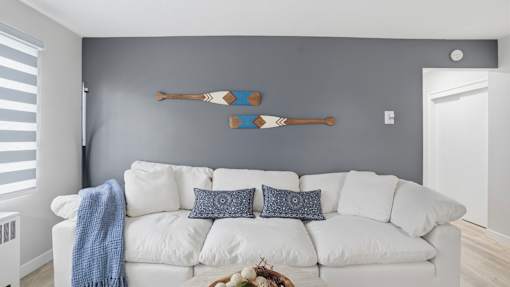 A white couch with a blue throw blanket on it.