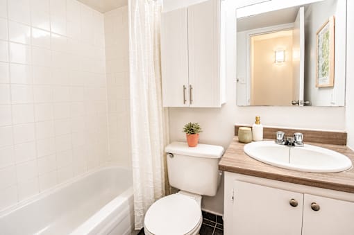 A white bathroom with a toilet, sink, and bathtub.