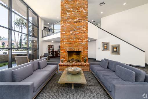 a living room with couches and a large brick fireplace
