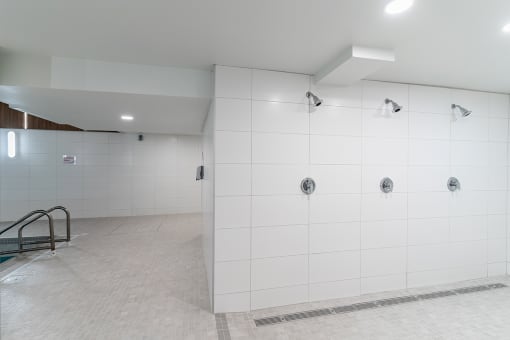a large white shower in a bathroom with a tiled floor