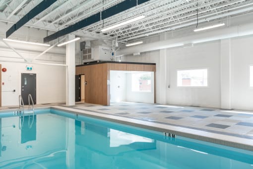 a large indoor swimming pool with white walls and ceilings