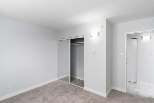 a bedroom with grey carpet and white walls