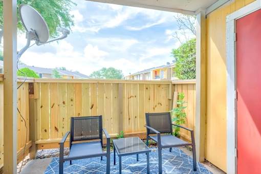 A small balcony with a table and two chairs.