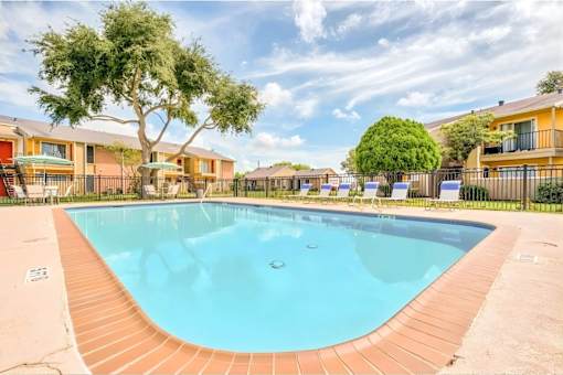 A swimming pool surrounded by a fence and trees.