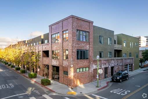 A street view of a building with a car parked in front.