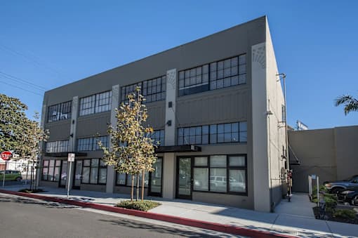 A modern building with a grey facade and large windows.