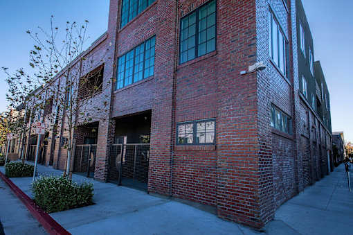 A red brick building with a tree in front of it.