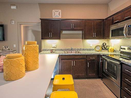 A kitchen with brown cabinets and a white counter.