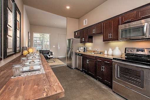 A modern kitchen with dark wood cabinets and stainless steel appliances.