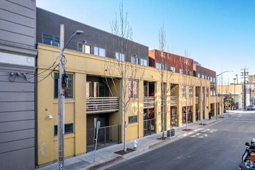 A street view of a row of buildings with a clear blue sky above.