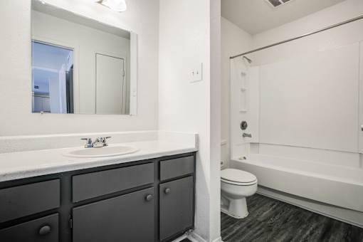 A bathroom with a sink, toilet, and bathtub.